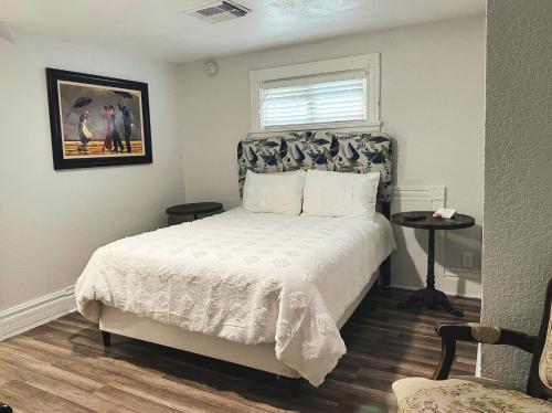 a bedroom with a white bed and a window at The Mansion on 17th, formerly Schaefer Haus in Galveston