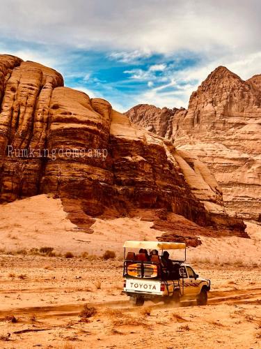 a white van driving through the desert at Rum Kingdom Camp in Wadi Rum