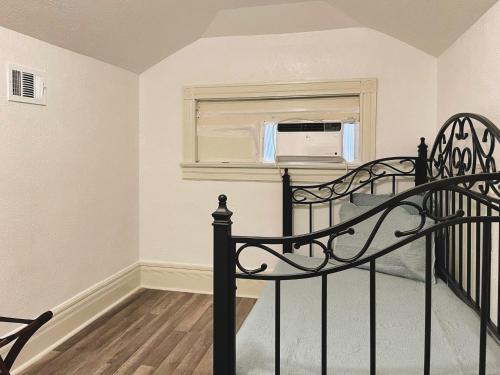 a bedroom with a bed and a window with a microwave at The Mansion on 17th, formerly Schaefer Haus in Galveston