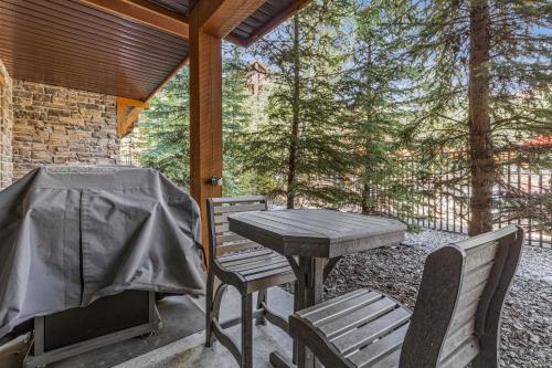 a patio with a table and chairs and a grill at Stoneridge Mountain Resort Condo managed by Little Sister Getaways in Canmore