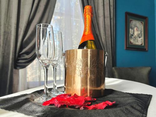a bottle of champagne in a bucket on a table with glasses at The Mansion on 17th, formerly Schaefer Haus in Galveston