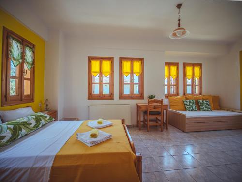 a bedroom with a bed and a couch and windows at Lemon House for big family in Damouchari - Delicious Houses in Damouchari