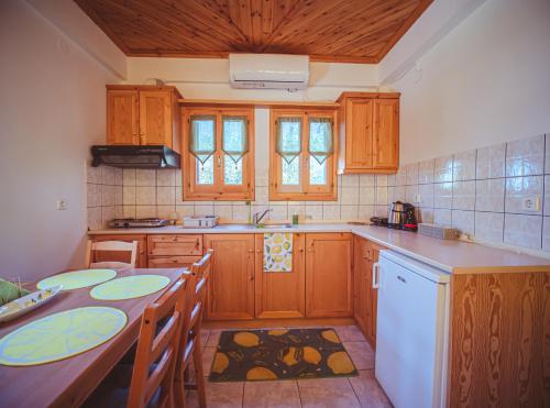 a kitchen with wooden cabinets and a table with chairs at Lemon House for big family in Damouchari - Delicious Houses in Damouchari