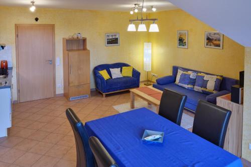- un salon avec une table bleue et un canapé dans l'établissement 4 Kreuzstraße Laaschhof, à Nusbaum