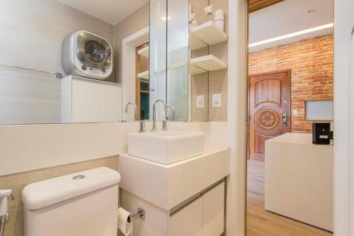 W łazience znajduje się umywalka, toaleta i lustro. w obiekcie Otimo loft c WiFi a 500m da Praia de Copacabana RJ w mieście Rio de Janeiro