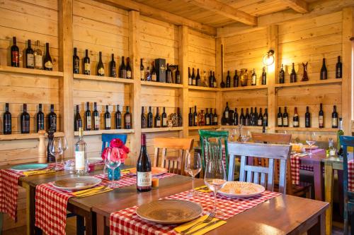 een eetkamer met een tafel en flessen wijn bij Burzan Bungalovi in Podgorica