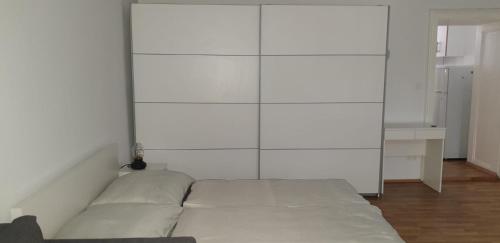 a bed in a room with a white wall at Ferienwohnung Schloessel 26-26 in Vienna