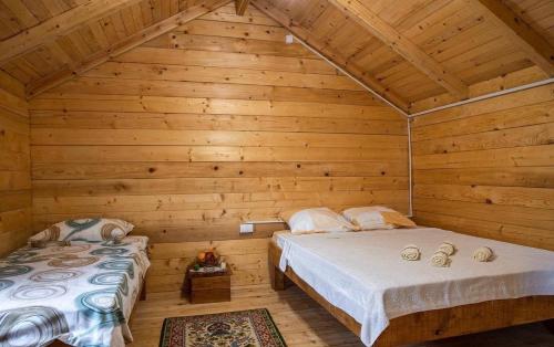 a bedroom with two beds in a log cabin at Burzan Bungalovi in Podgorica