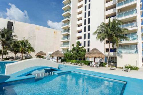 a swimming pool in front of a building at Beach Front Renewed Apartment in Cancún