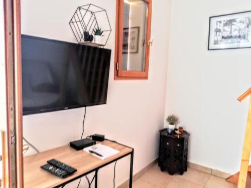uma sala de estar com uma grande televisão na parede em Rez de jardin dans quartier calme et ensoleillé em Saint-André-les-Alpes