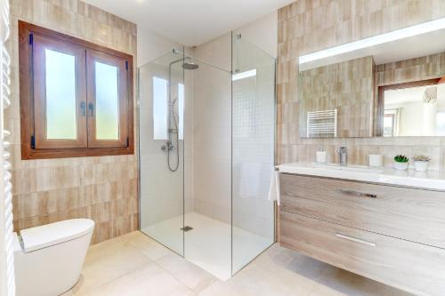 ein Bad mit einer Dusche, einem WC und einem Waschbecken in der Unterkunft Villa Casa de Pedra by Villa Plus in Crestatx