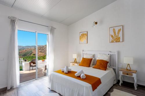 - une chambre blanche avec un lit et un balcon dans l'établissement Villa Piedras Blancas by Villa Plus, à Frigiliana