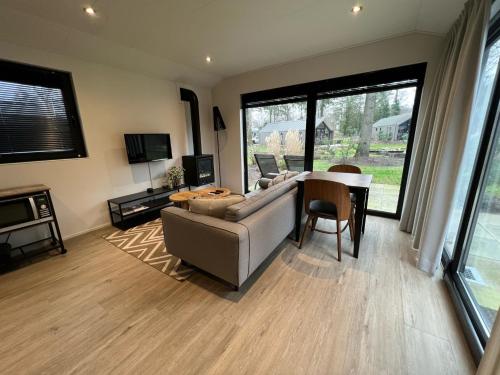 a living room with a couch and a table at Holiday Home Maridu Wellness in Arnhem