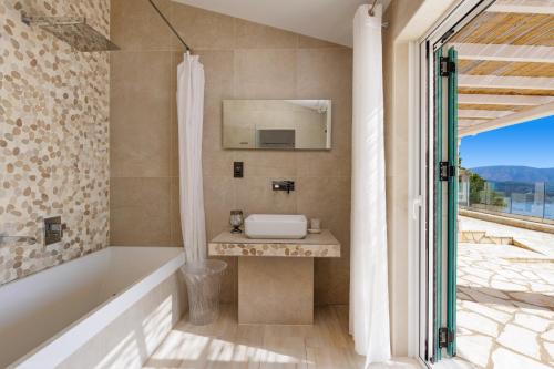 ein Badezimmer mit einer Badewanne und einem Waschbecken in der Unterkunft Villa Ester by Villa Plus in Kalámi