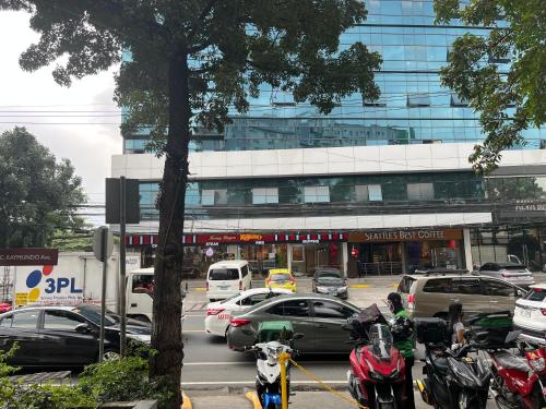 a parking lot with cars and motorcycles in front of a building at The Cozy Place Condo in Pasig Phil in Manila