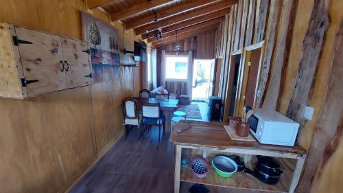 a kitchen and dining room of a log cabin at Cabañas & Habitaciones Del Alto in Hornopiren