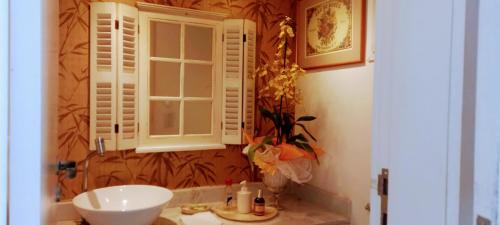 uma casa de banho com um lavatório e uma janela em La Tropezina em Búzios