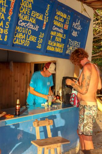 a man and a woman preparing food at a counter at Dahlandia in Isla Mucura