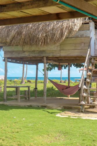 a hammock in a hut with a view of the ocean at Dahlandia in Isla Mucura
