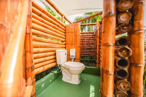 La salle de bains est pourvue de toilettes et d'un mur en bois. dans l'établissement Cerro Tusa Glamping, à Titiribí