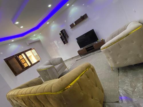 a living room with two couches and a flat screen tv at RESIDENCE EL HADJI in Dakar