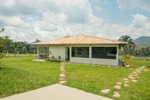 ein kleines weißes Haus mit einem Rasenhof in der Unterkunft EIT Eco Inteligente in Alto Paraíso de Goiás