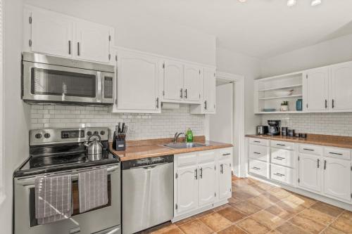 a kitchen with white cabinets and stainless steel appliances at Charming 1 BR Spacious Retreat [Sage Suites] 