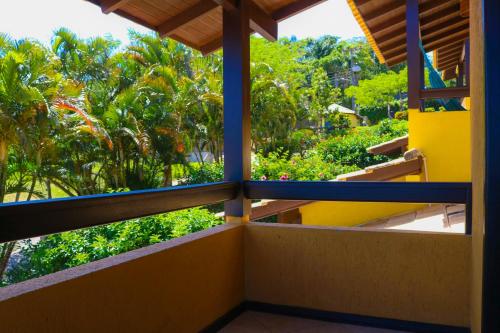 a balcony with a view of trees and bushes at Pousada Flor de Lotus in Praia do Rosa