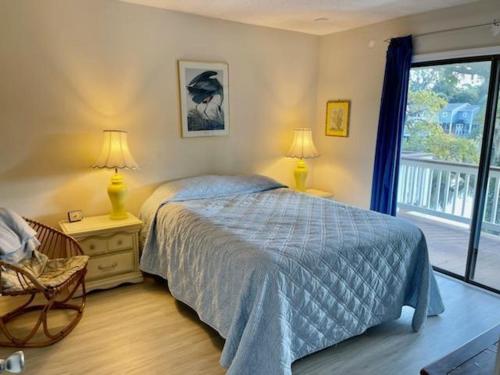 - une chambre avec un lit, deux lampes et une fenêtre dans l'établissement Austin's Serenity, à Edisto Island