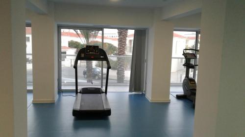 a gym with a treadmill in a room with a window at Captain Pier Hotel in Protaras