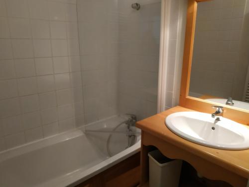 une salle de bain avec un lavabo et une baignoire dans l'établissement L'APPARTEMENT DU BONHEUR, à Super-Besse