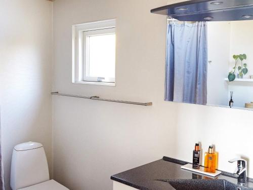 La salle de bains est pourvue d'un lavabo, de toilettes et d'une fenêtre. dans l'établissement Holiday home Slagelse XLII, à Slagelse