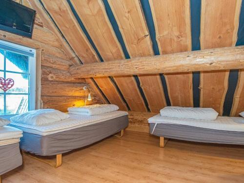 two beds in a room with a wooden ceiling at 18 person holiday home in Ansager in Ansager