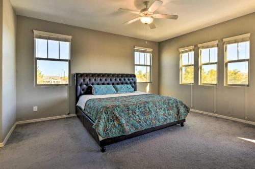 a bedroom with a bed with a ceiling fan and windows at Spacious Gilbert Vacation Rental with Patio! in Gilbert
