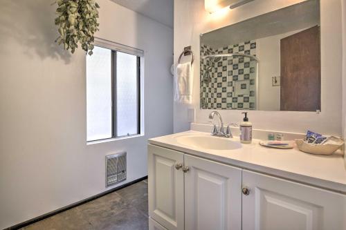 een badkamer met een wastafel, een spiegel en een raam bij Cozy California Abode Near Malibu Beaches! in Topanga