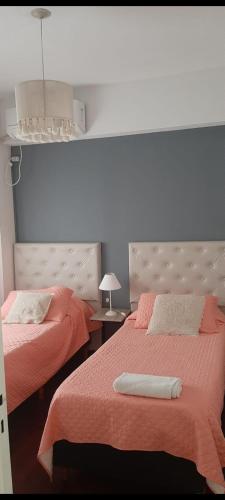 1 dormitorio con 2 camas con sábanas rosas en Hermoso departamento Tucuman en San Miguel de Tucumán