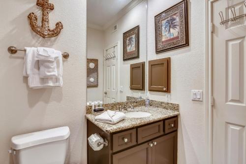 a bathroom with a sink and a toilet and a mirror at Dawn 722-Poolside Paradise in Galveston