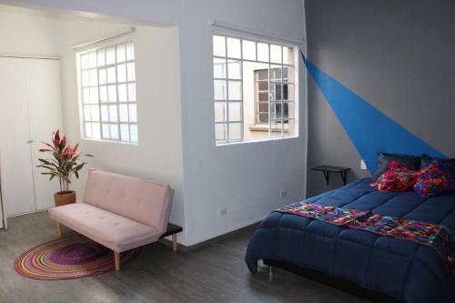 1 dormitorio con 1 cama azul y 1 silla en Am Condesa en Ciudad de México