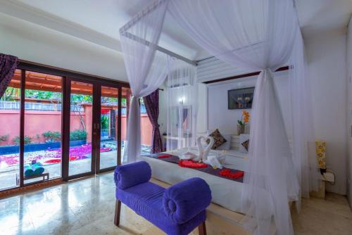 a bedroom with a bed and a purple chair at One Bedroom Private Pool Kuta in Kuta