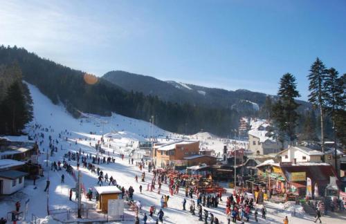 a crowd of people walking around a ski resort at Lodge Euphoria Apartment in Borovets