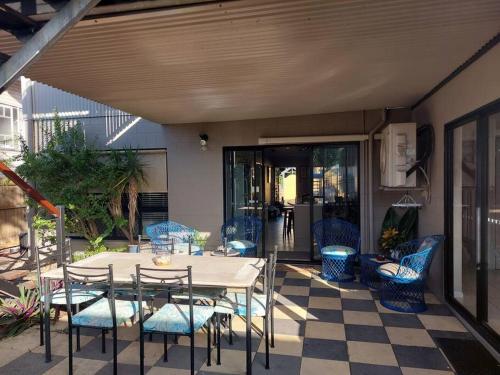 a patio with a table and chairs on a checkered floor at City centre, tropical home, minutes walk to shops. in Cairns