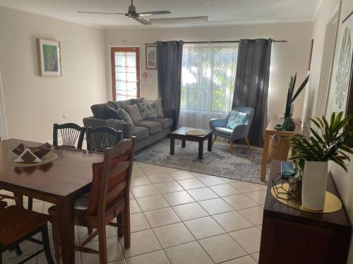 a living room with a couch and a table at City centre, tropical home, minutes walk to shops. in Cairns