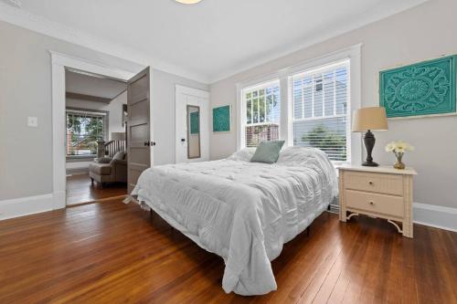 um quarto branco com uma cama, uma secretária e janelas em Beautiful Historical home in Fisher Park! 4BR 3BA em Greensboro
