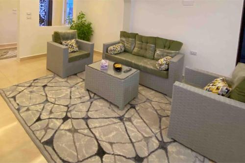 a living room with two couches and a rug at بيت العُمري (ام قيس) in Um Qeis