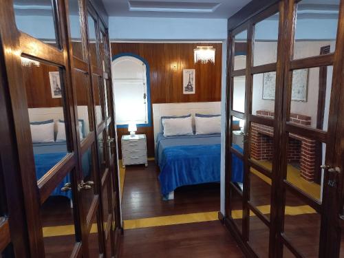a bedroom with a blue bed and a mirror at Pousada Solar Azul in Miguel Pereira