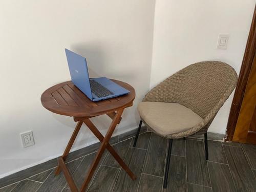 a laptop sitting on a table next to a chair at HOTEL EL CORAL in Punta Mita