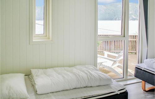 a bed sitting in a room next to a window at Stunning Home In Farsund With 4 Bedrooms, Jacuzzi And Sauna in Herad