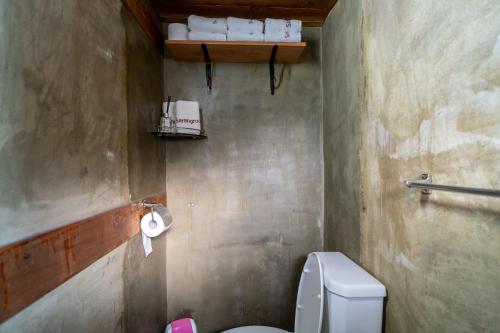 a bathroom with a toilet and towels on a shelf at Sarangroo in Jeonju