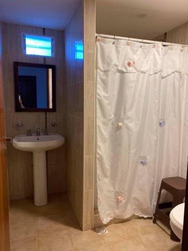a bathroom with a white shower curtain and a sink at Camino al Sol Domselaar wifi in Domselaar