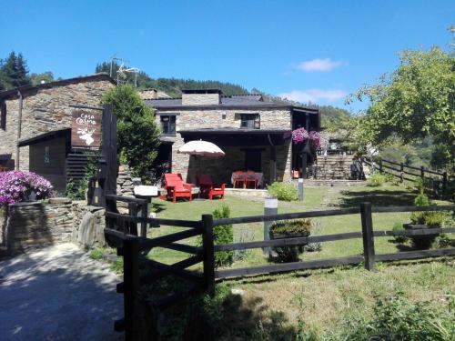 ein Bauernhaus mit einem Zaun davor in der Unterkunft Casa Calma Rural in Taramundi